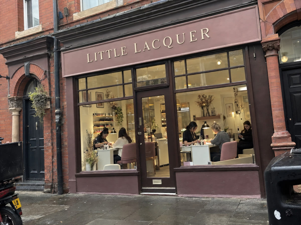Little Lacquer nail salon storefront with customers receiving nail services inside